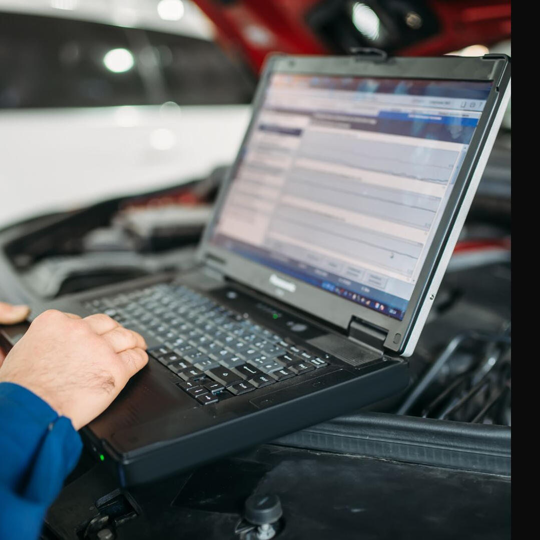 Person on a computer doing a diagnostic test to diagnose car issues in order to perform services and repairs for the car.